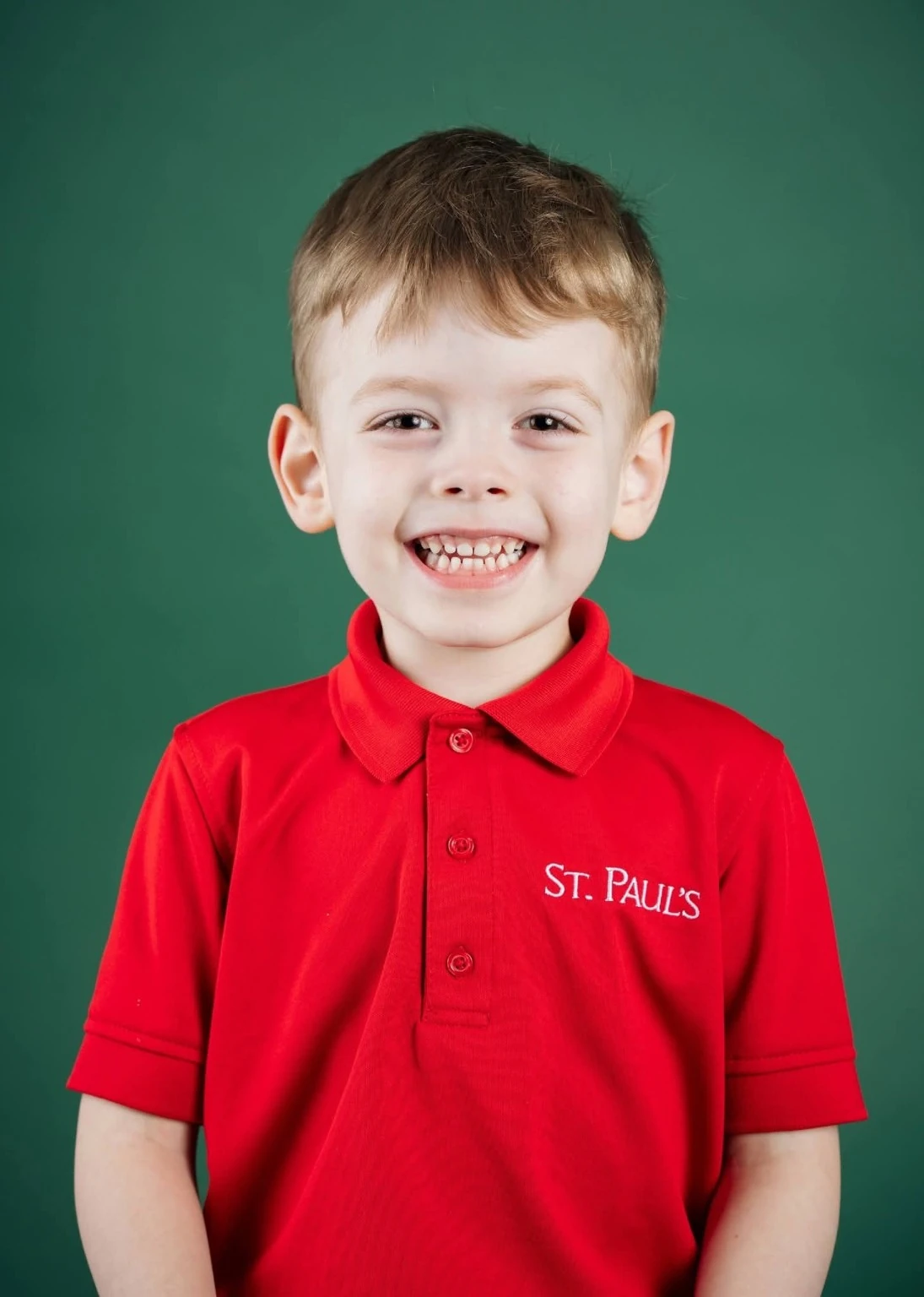 Michael smiling in his red St. Paul's polo against a green studio background